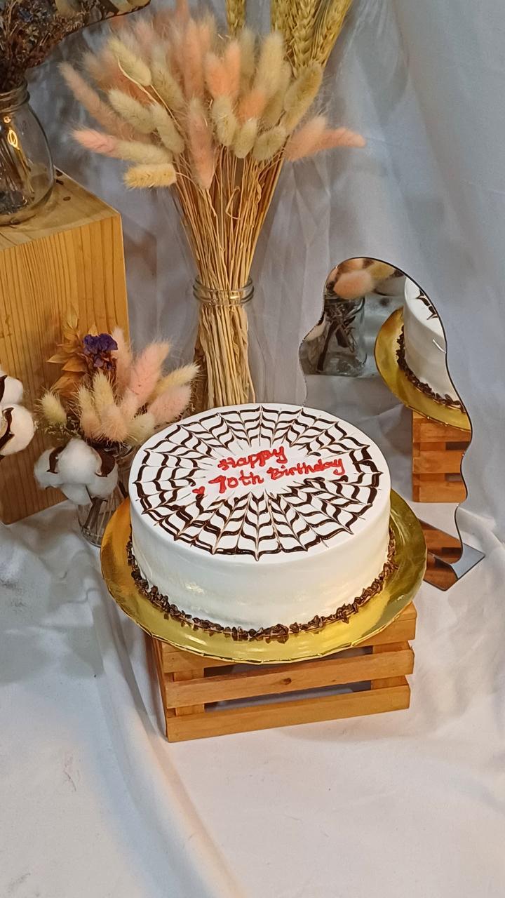 D24 Durian Cake — whole round cake with chocolate spider web design and Happy 70th Birthday message on gold plate