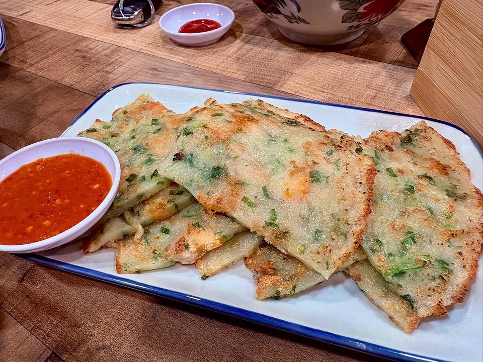 Folded omelettes or pancakes with red dipping sauce at Uncle Soon Plus Kitchen House