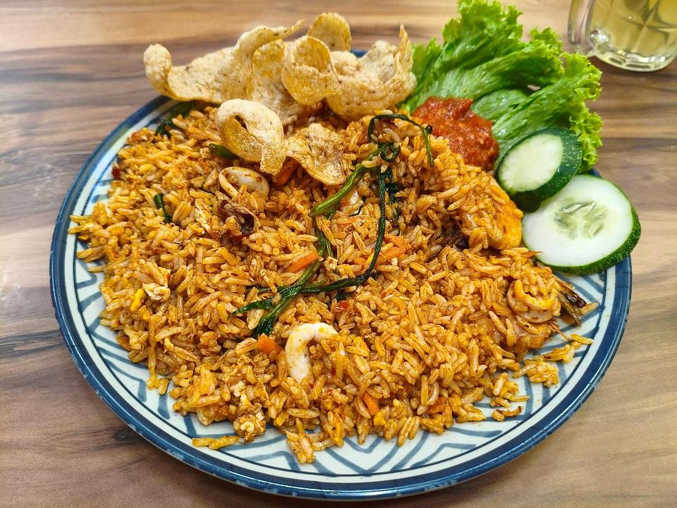 Nasi goreng with shrimp, vegetables, salad, and crispy crackers at Mace Mache