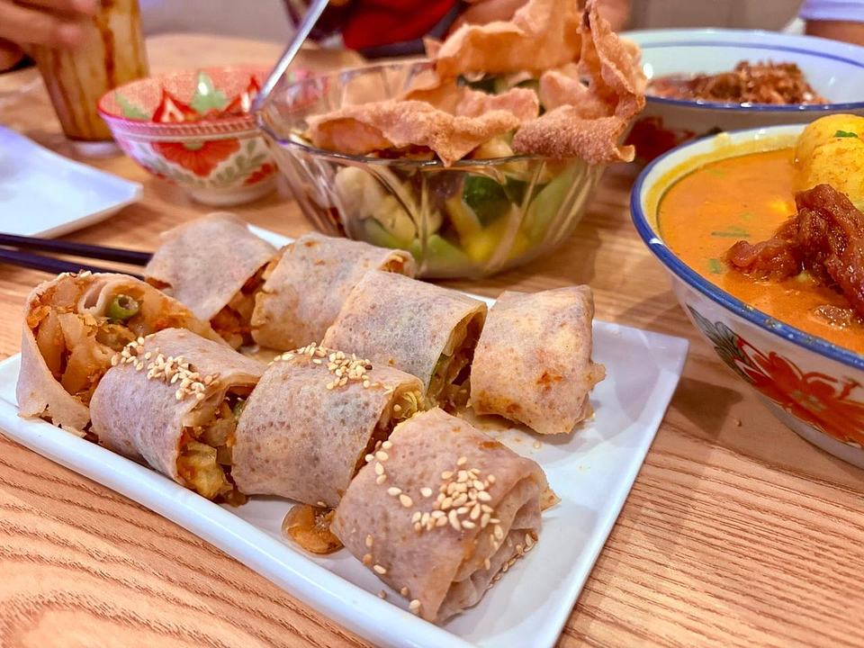 Popiah spring rolls with curry broth and vegetable sides at Bibi's Popiah