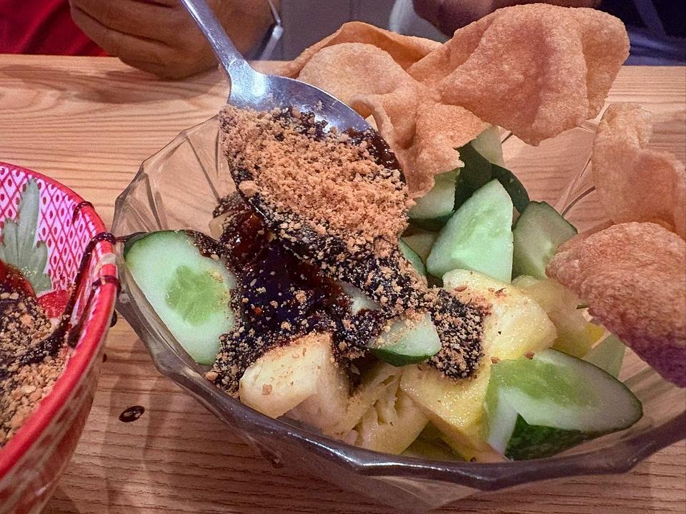 Fresh fruit salad with cucumber, pineapple, and crunchy topping at Bibi's Popiah