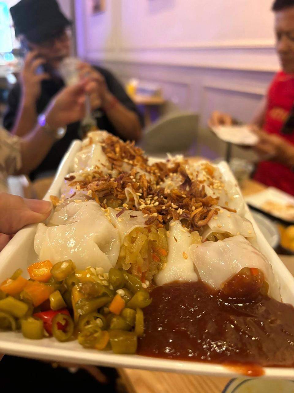 Steamed dumplings with crispy fried onions, pickled vegetables, and soy sauce at Bibi's Popiah