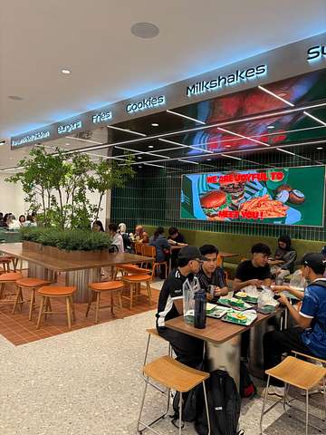 Dining area inside NakNak Sunway Pyramid with burgers, fries, cookies and milkshakes signage